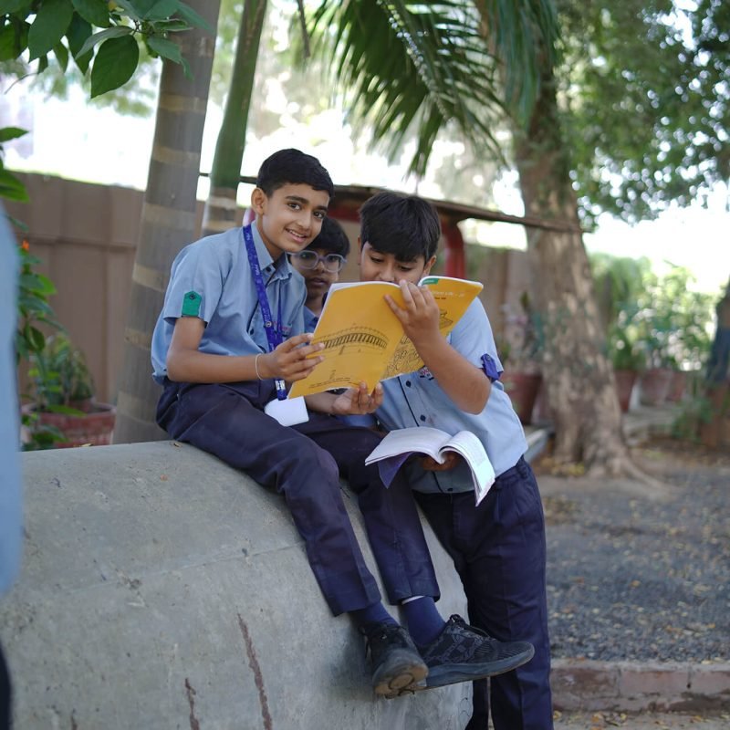 Students Reading Books Together Outdoors on Campus