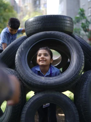 Girl Peeking Through Tire Play