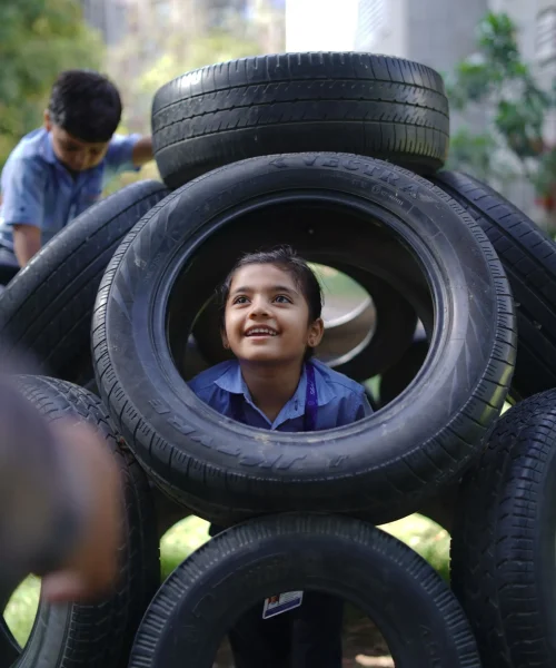 Girl Peeking Through Tire Play