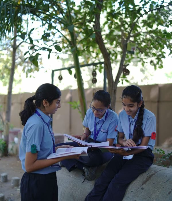 School Students Reading Books Together Outdoors in Campus Courtyard