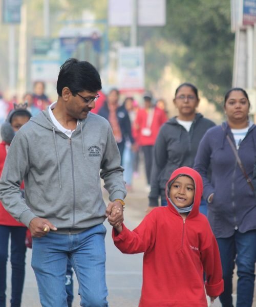 Father and Child Holding Hands During Community Morning Walk Event