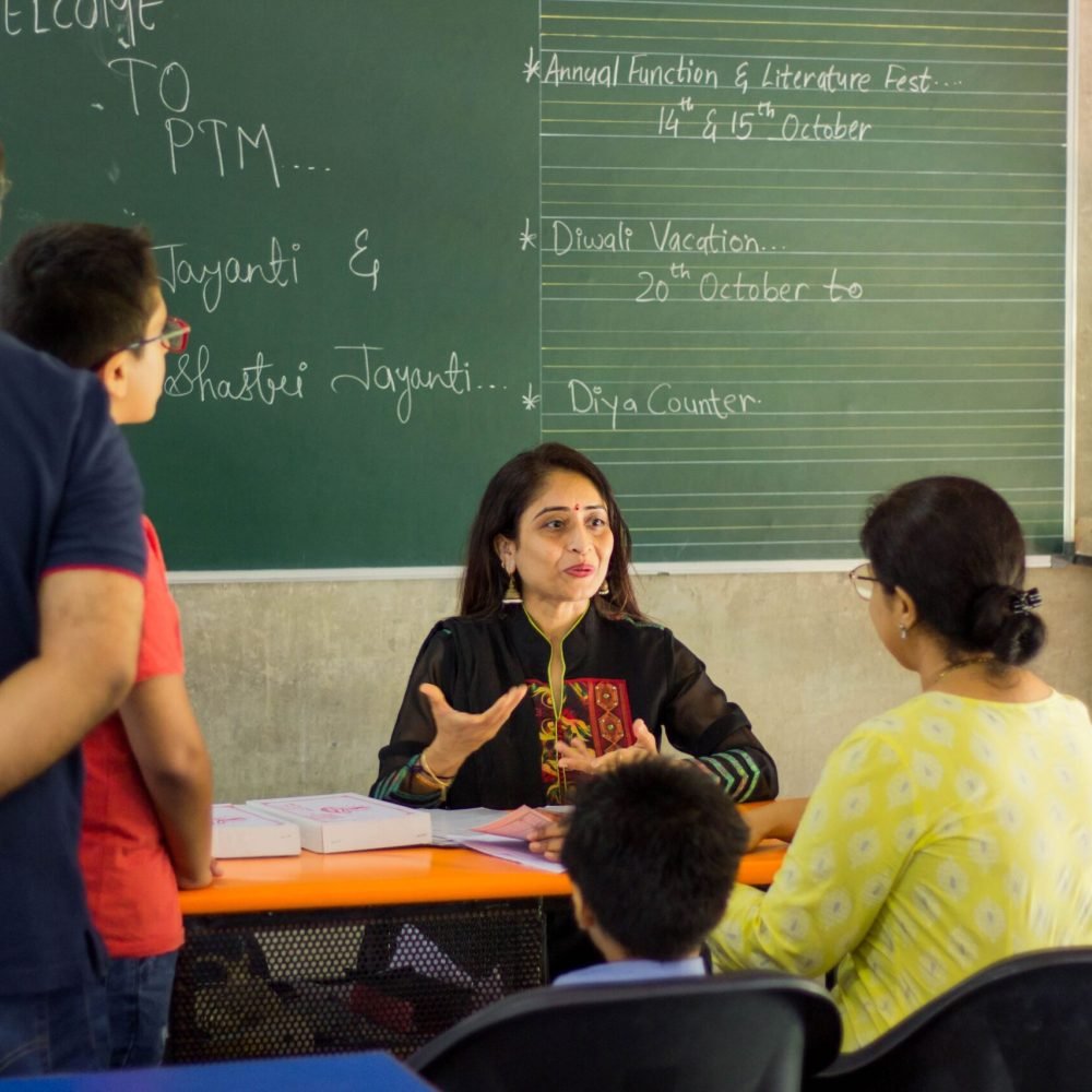 Teacher Interacting with Parents and Students During Parent-Teacher Meeting