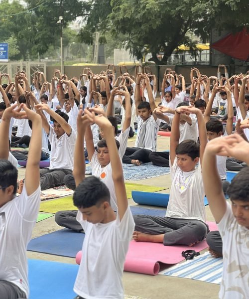 Students Practicing Mass Yoga Session Outdoors on Campus Grounds